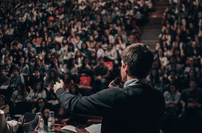 Man giving speech in front of large crowd